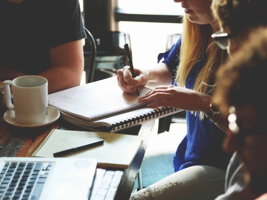 People collaborating at a table with notebooks.