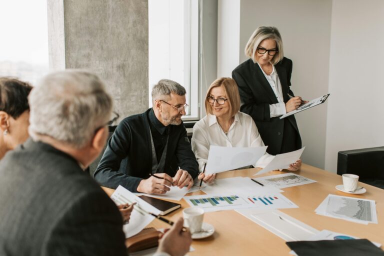 Business team discussing documents in a bright office meeting.