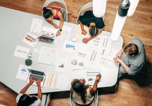 Team collaborating on data analysis and strategy around a table.