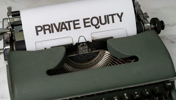 Typewriter with paper reading 'PRIVATE EQUITY'.