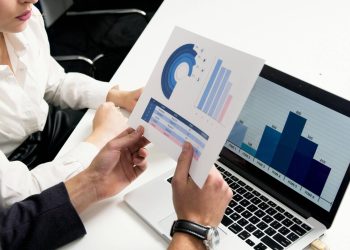 Business professionals discussing data charts and graphs in a modern office setting.